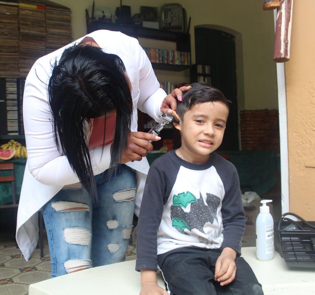 A SAI healthcare worker examines a young boy’s ear during a medical visit in Venezuela.