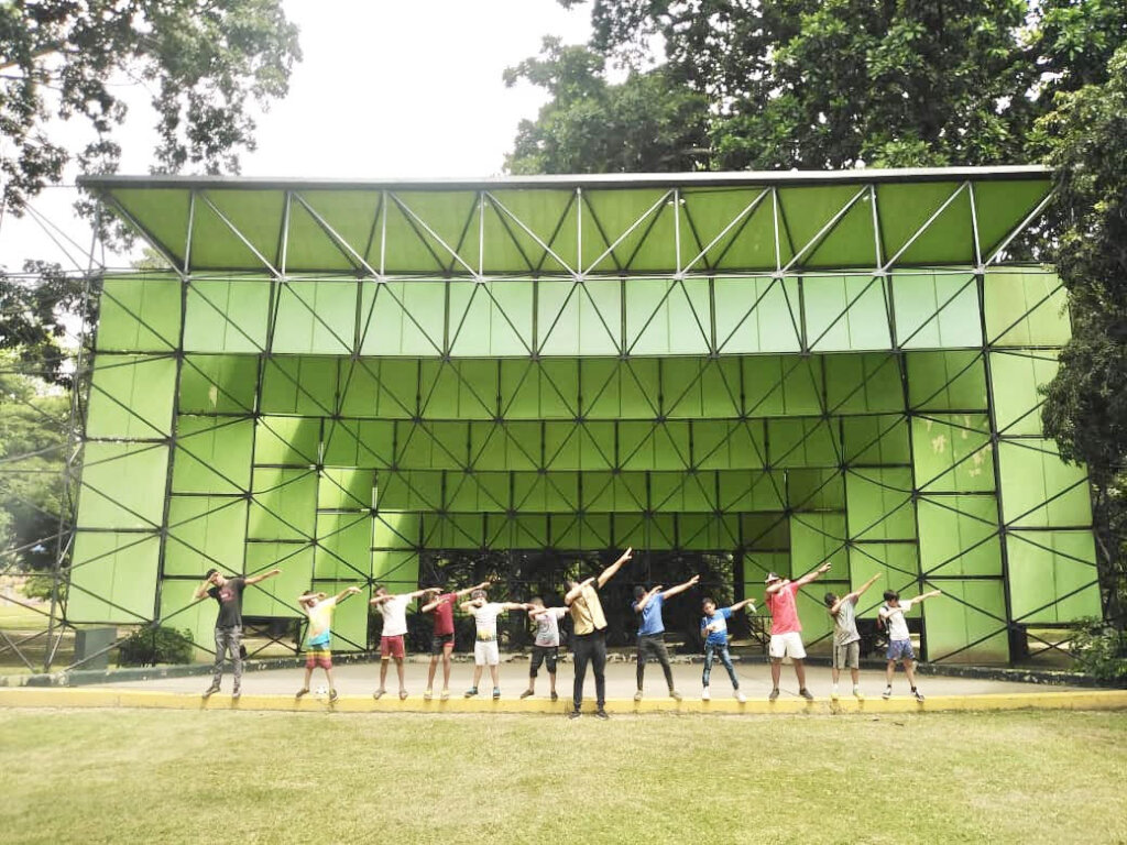 A group of children and teens stands outdoors in Venezuela during a group activity.