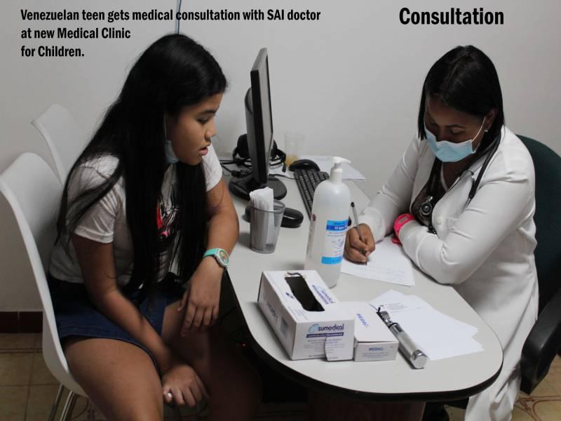 A teenage patient speaks with a doctor during a medical consultation at SAI Medical Clinic in Venezuela.