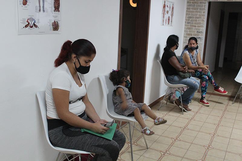 Patients and family members sit in a clinic waiting area before a medical check-up in Venezuela.