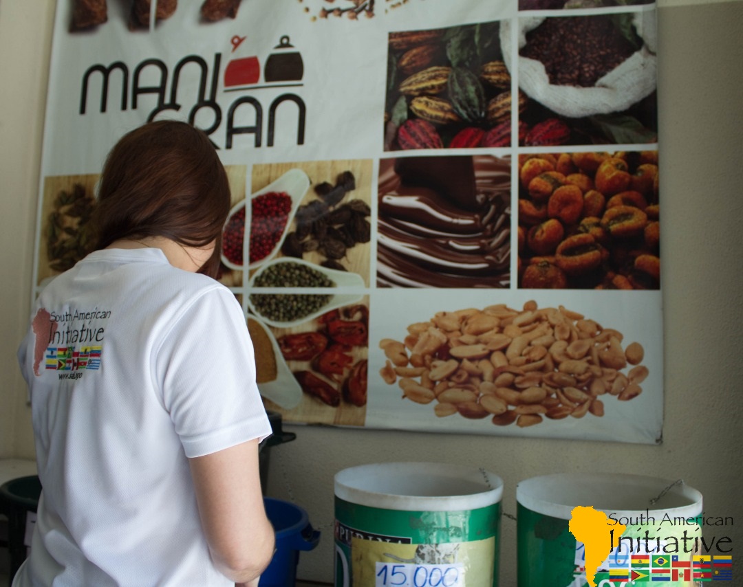 SAI volunteer standing near food supply containers during a humanitarian support activity in Venezuela.