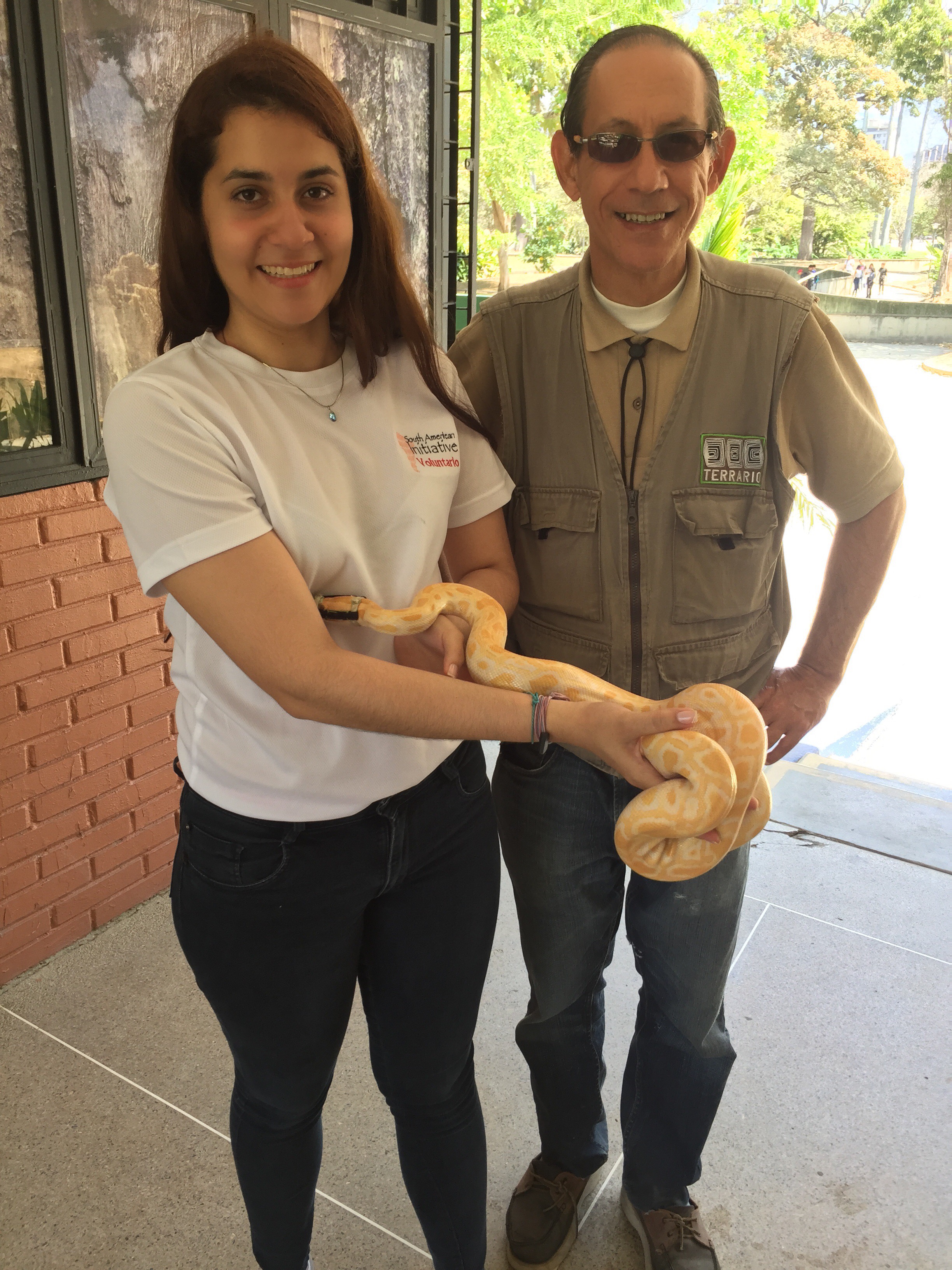 SAI volunteer holding a snake alongside a wildlife care staff member in Venezuela.