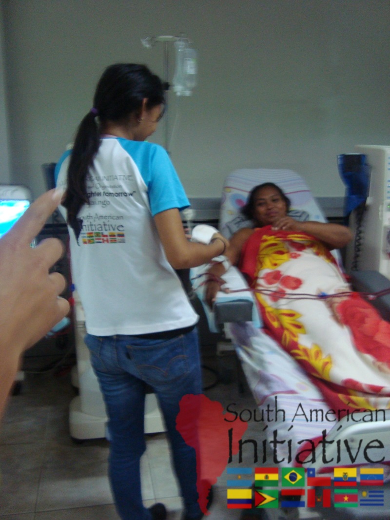 An SAI volunteer assisting a patient receiving medical treatment in a hospital in Venezuela.