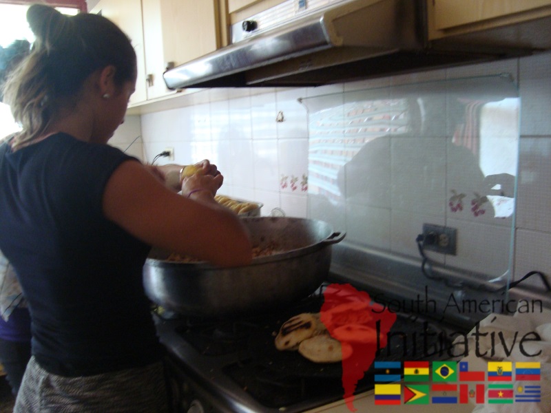 A volunteer preparing food in a kitchen as part of SAI humanitarian work in Venezuela.