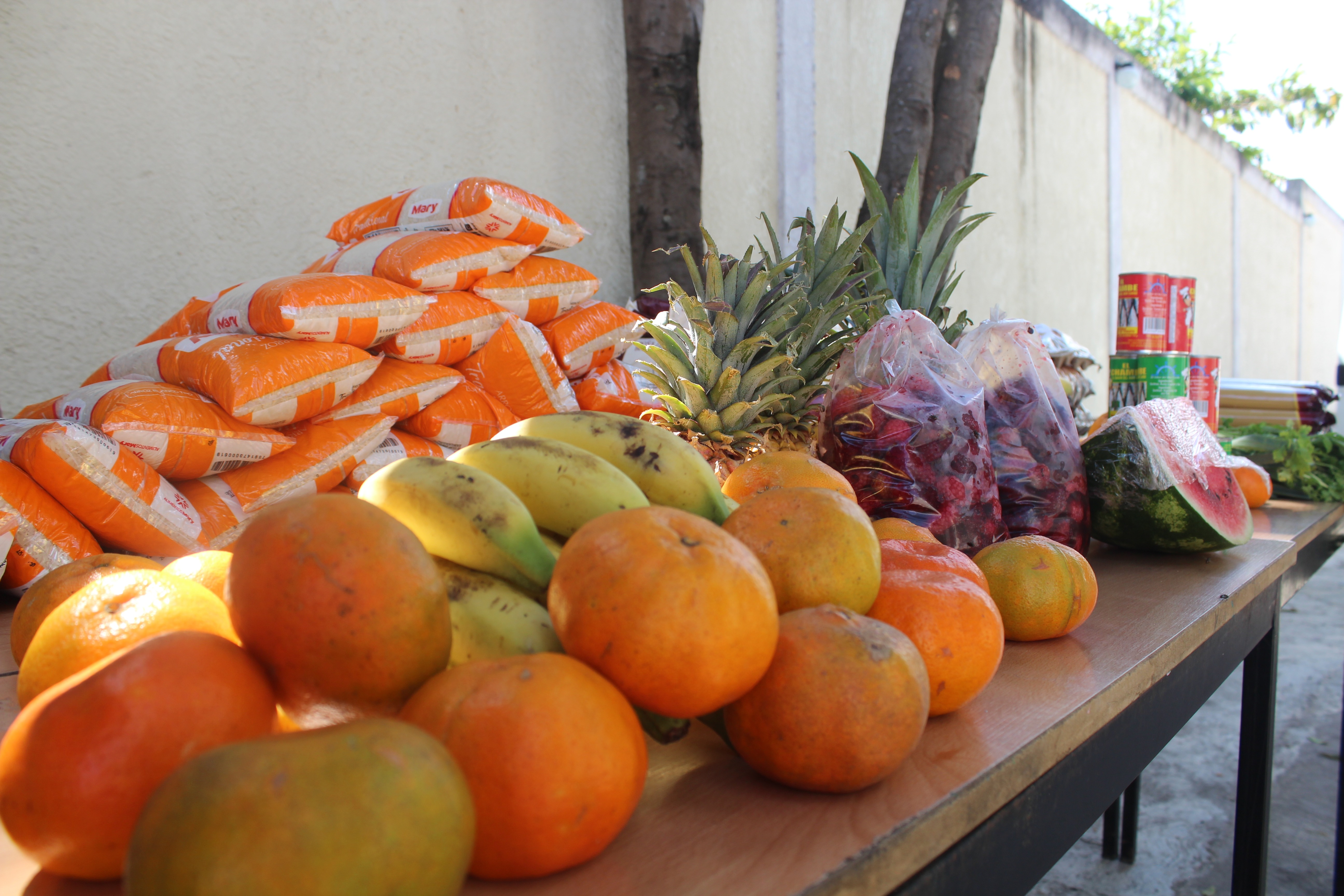 Fresh fruit, produce, and packaged food arranged on tables for distribution through SAI in Venezuela.