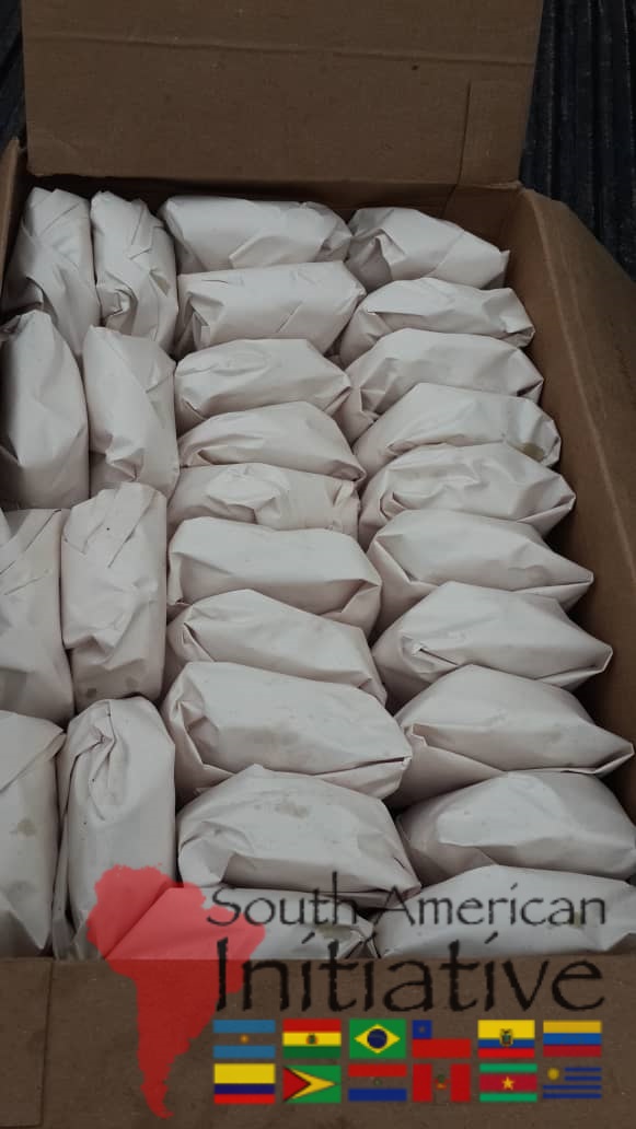 A box filled with individually wrapped meal packages prepared for humanitarian relief by South American Initiative.