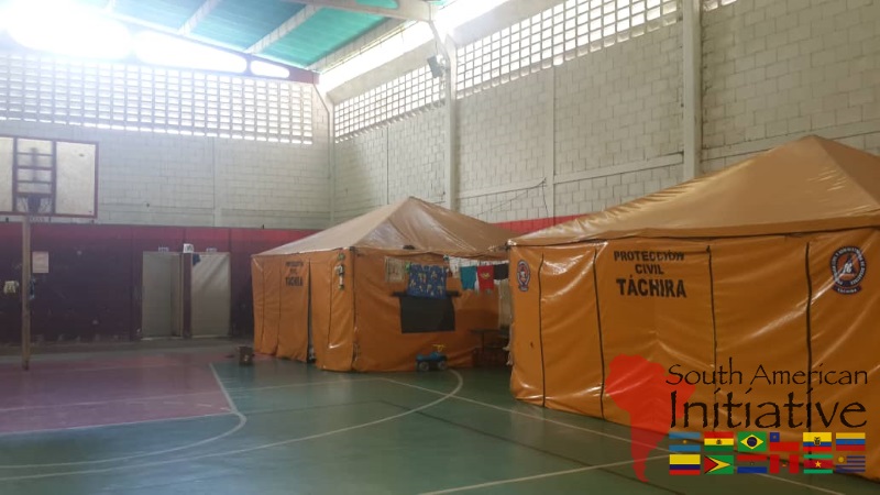 Emergency shelter tents are set up inside a covered facility in Venezuela.