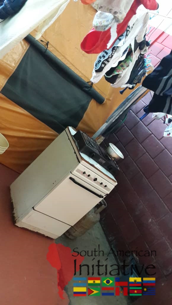 A stove and cooking area inside a refugee shelter supported by South American Initiative.