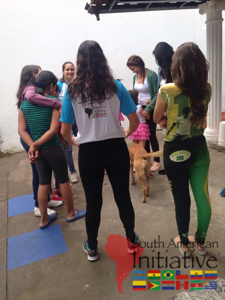 SAI volunteers stand with refugee families during a support visit in Venezuela.