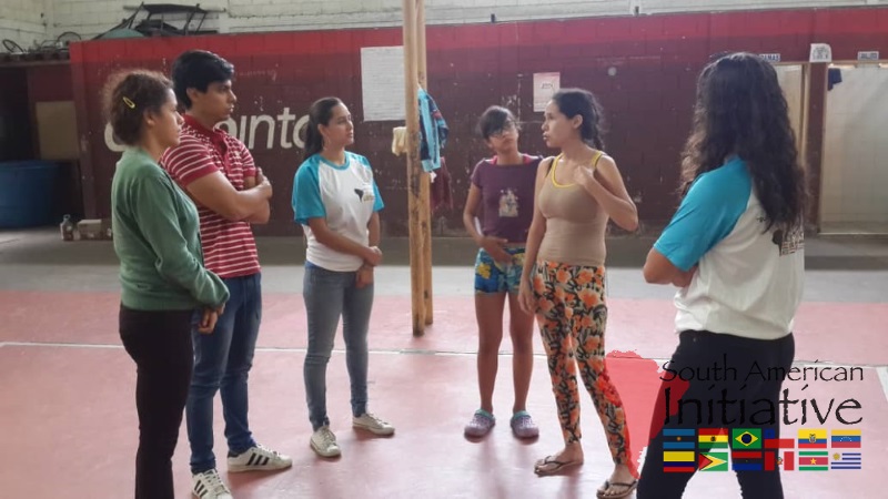 Volunteers and refugees stand together inside an emergency shelter facility in Venezuela.