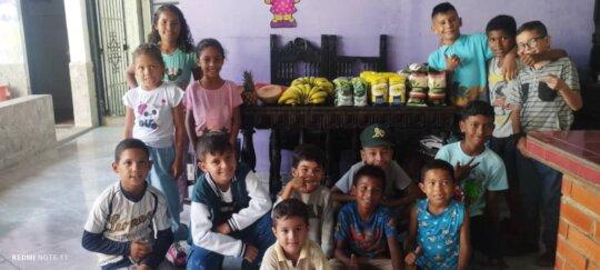 South American Initiative Feeds Orphans in Venezuela The South American Initiative, a dedicated non-profit organization, provides nourishing meals to orphaned children in Venezuela. In this image, children gather around a table filled with fresh bananas, peanut butter, and other essentials—highlighting the organization's mission to combat hunger and improve the well-being of vulnerable youth. Through generous donations and volunteer efforts, SAI continues to deliver free food, medicine, and educational materials, offering orphans the support they need for a brighter future.